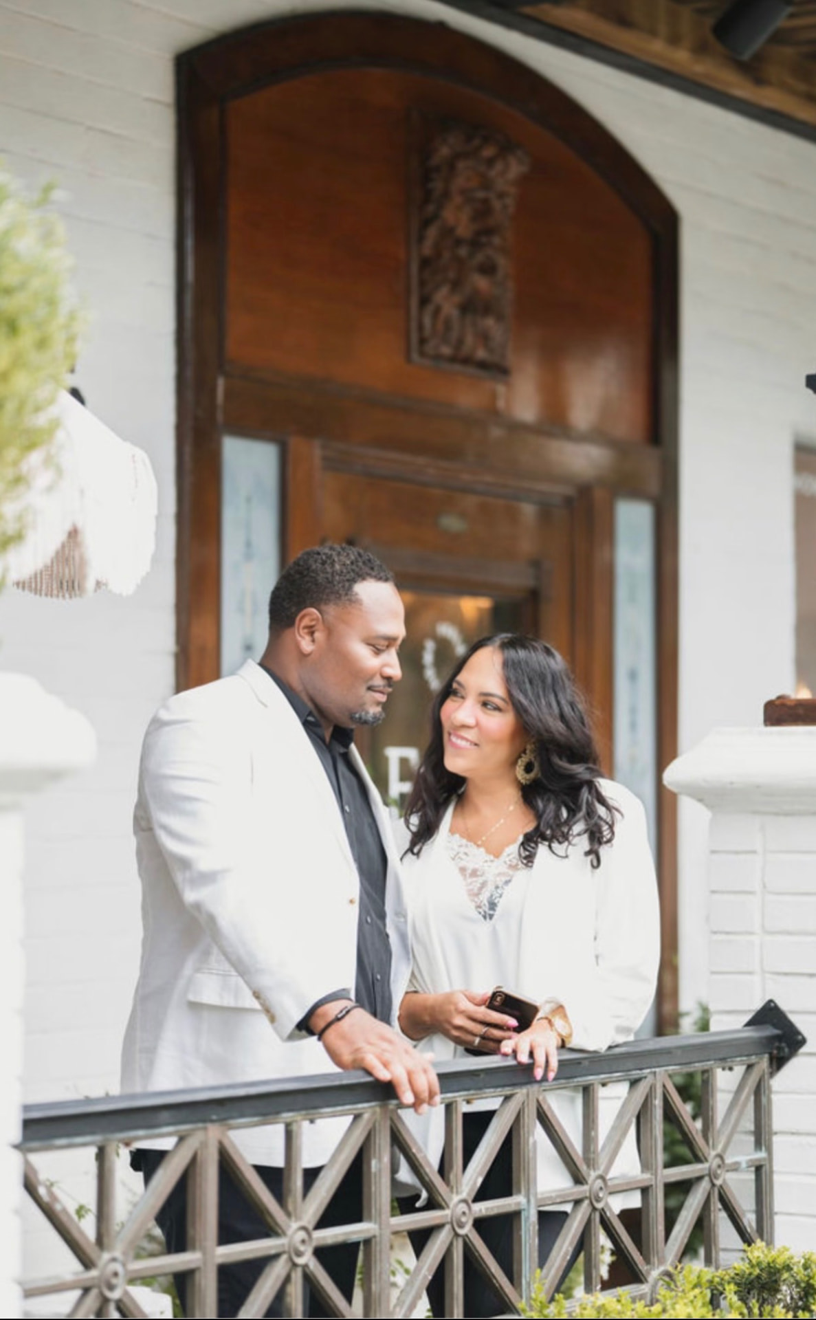 Jevon and Cindy Williams standing together on a porch outside a white brick building in Wesley Chapel.